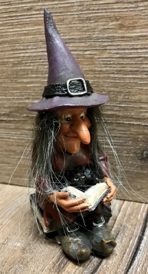 Figur - Lustige Hexe liest - sitzt auf Büchern - mit Buch